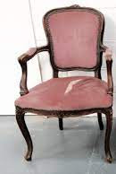 French armchair with a carved frame and worn rose velvet